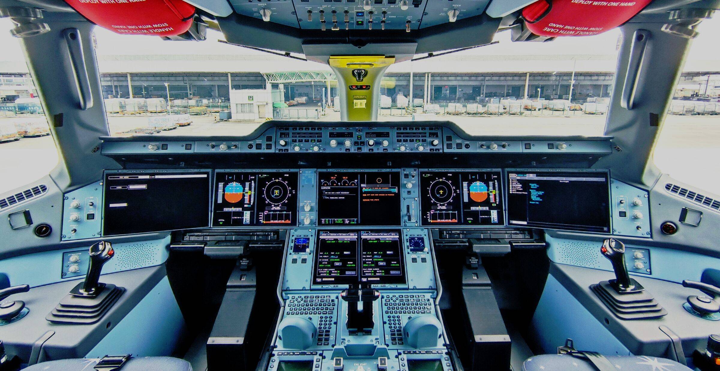 The cockpit of a plane sat at an airport terminal.